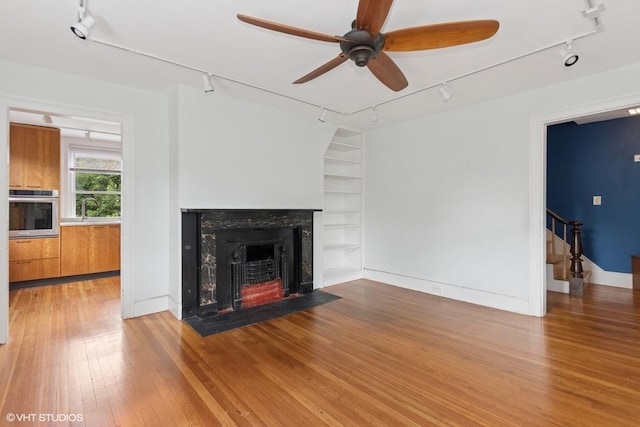 4 Dewindt St, Beacon, NY 12508 - unfurnished living room featuring track lighting, built in features, a ceiling fan, hardwood / wood-style floors, and a fireplace