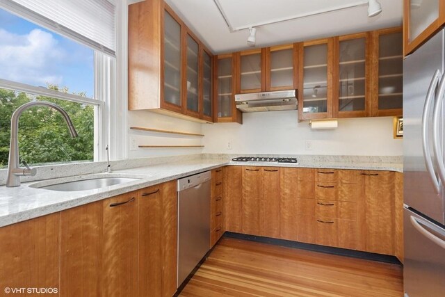4 Dewindt St, Beacon, NY 12508 - kitchen with appliances with stainless steel finishes, under cabinet range hood, light wood finished floors, brown cabinetry, and light stone countertops