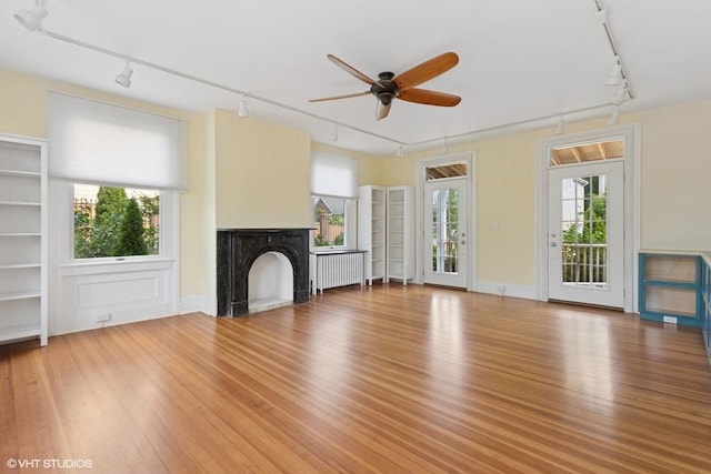 4 Dewindt St, Beacon, NY 12508 - unfurnished living room featuring track lighting, a ceiling fan, light wood finished floors, a fireplace, and radiator heating unit