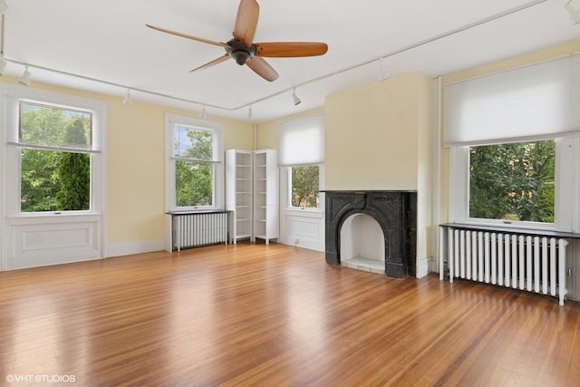 4 Dewindt St, Beacon, NY 12508 - unfurnished living room featuring rail lighting, radiator, wood finished floors, and ceiling fan