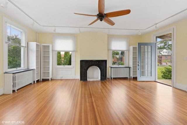 4 Dewindt St, Beacon, NY 12508 - unfurnished living room with track lighting, radiator heating unit, a ceiling fan, and wood finished floors