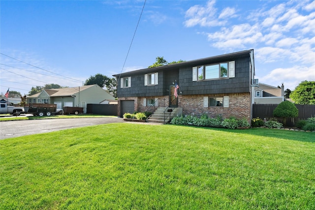 1583 5th St, West Babylon, NY 11704 - raised ranch featuring brick siding, asphalt driveway, and an attached garage