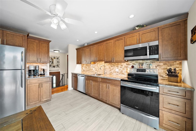 1583 5th St, West Babylon, NY 11704 - kitchen with stainless steel appliances, backsplash, ceiling fan, light stone counters, and light wood-type flooring