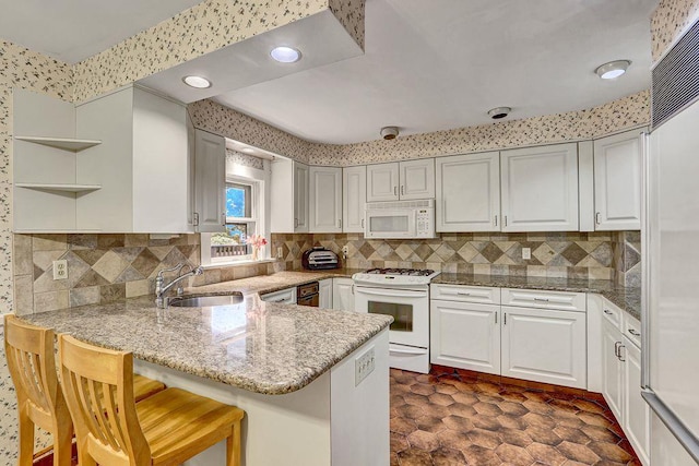 313 Pine St, Freeport, NY 11520 - kitchen featuring white appliances, a peninsula, open shelves, white cabinets, and decorative backsplash