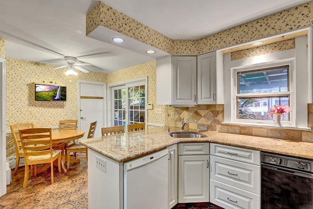 313 Pine St, Freeport, NY 11520 - kitchen with dishwasher, a ceiling fan, wallpapered walls, a peninsula, and decorative backsplash