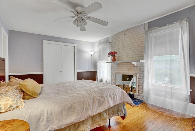 313 Pine St, Freeport, NY 11520 - bedroom featuring wood-type flooring, a ceiling fan, a closet, and a fireplace