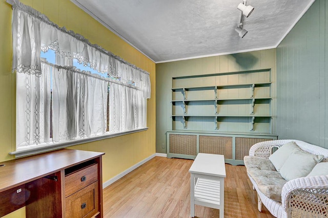 313 Pine St, Freeport, NY 11520 - sitting room featuring radiator heating unit, ornamental molding, light wood-style floors, and wooden walls