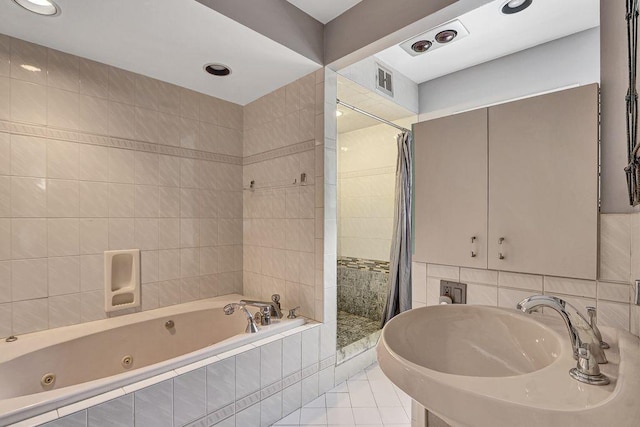 313 Pine St, Freeport, NY 11520 - full bathroom featuring a tub with jets, tile walls, tiled shower, tile patterned floors, and recessed lighting
