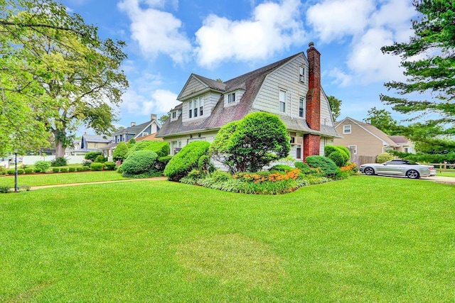 313 Pine St, Freeport, NY 11520 - view of home's exterior featuring a gambrel roof, a lawn, a chimney, and a residential view