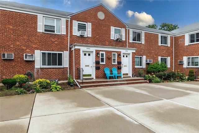 71-12 260th St Fl H 1St, Glen Oaks, NY 11004 - view of property with brick siding, a wall mounted AC, and cooling unit