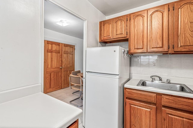35-51 85th St Unit 2F, Jackson Heights, NY 11372 - kitchen with freestanding refrigerator, light countertops, backsplash, and brown cabinetry