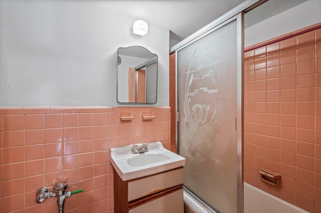 35-51 85th St Unit 2F, Jackson Heights, NY 11372 - full bathroom featuring vanity, tile walls, shower / bath combination with glass door, and a wainscoted wall