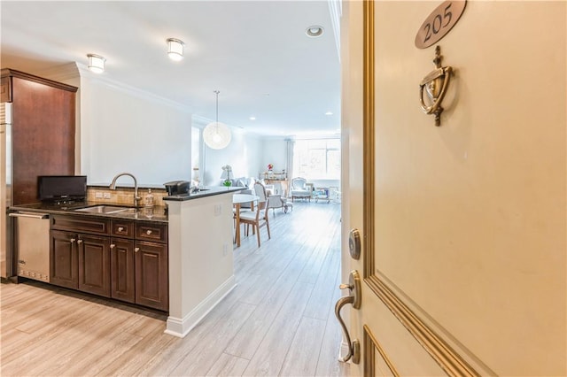 1 Christie Pl Unit 205E, Scarsdale, NY 10583 - kitchen with stainless steel dishwasher, light wood-style floors, dark brown cabinets, dark stone countertops, and crown molding