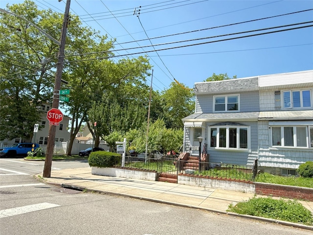 20401 34th Ave, Bayside, NY 11361 - view of front of home with a fenced front yard and roof with shingles