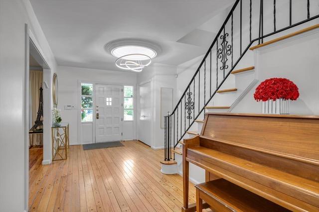 94 Fairview Ave, Great Neck, NY 11023 - entryway featuring stairway, hardwood / wood-style floors, and a chandelier