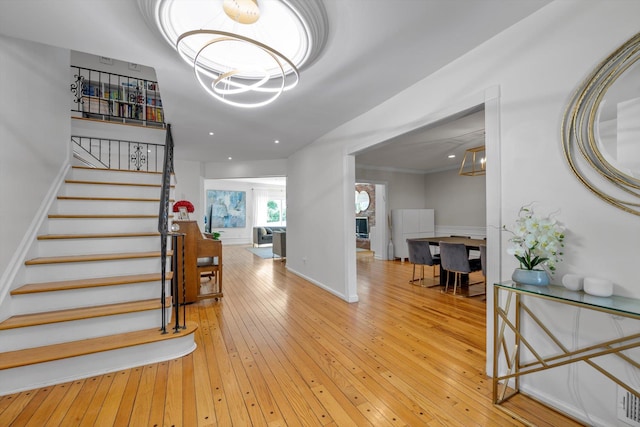 94 Fairview Ave, Great Neck, NY 11023 - foyer with light wood-style floors, a chandelier, and stairway