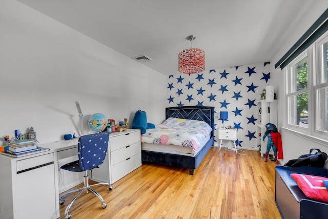94 Fairview Ave, Great Neck, NY 11023 - bedroom featuring wallpapered walls, light wood-type flooring, an accent wall, and an office area