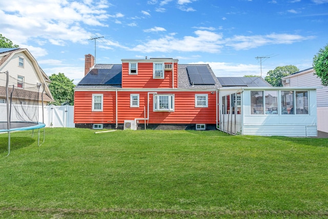 694 Koelbel Ct, Baldwin, NY 11510 - back of house with solar panels, a sunroom, a chimney, and a gate