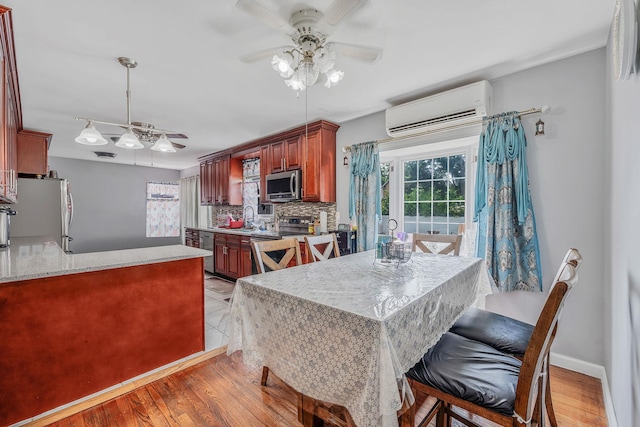 694 Koelbel Ct, Baldwin, NY 11510 - dining space featuring an AC wall unit, ceiling fan, and light wood finished floors