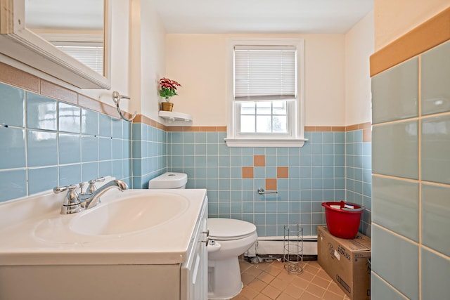 694 Koelbel Ct, Baldwin, NY 11510 - bathroom with tile patterned floors, vanity, a baseboard radiator, tile walls, and a wainscoted wall