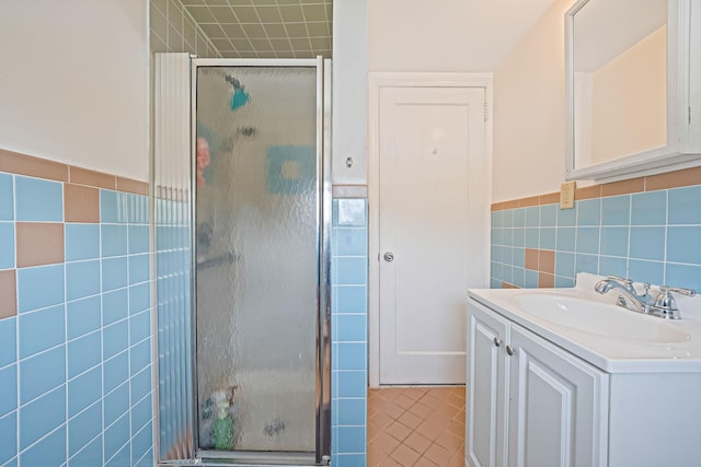694 Koelbel Ct, Baldwin, NY 11510 - full bathroom featuring tile walls, a shower stall, vanity, wainscoting, and tile patterned floors