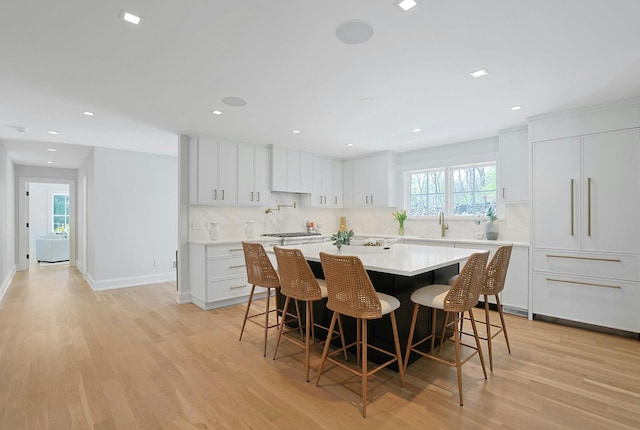 1 Devoe Rd, Armonk, NY 10504 - kitchen featuring tasteful backsplash, stainless steel gas cooktop, a kitchen bar, light wood-type flooring, and recessed lighting