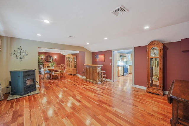 6 Sunrise Pl, Farmingville, NY 11738 - living area featuring light wood-type flooring, recessed lighting, a wood stove, and lofted ceiling