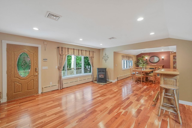 6 Sunrise Pl, Farmingville, NY 11738 - entryway featuring a wood stove, baseboard heating, light wood-style flooring, recessed lighting, and vaulted ceiling