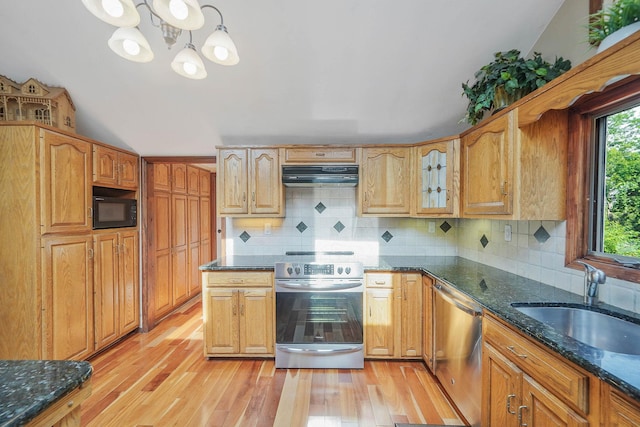 6 Sunrise Pl, Farmingville, NY 11738 - kitchen featuring appliances with stainless steel finishes, under cabinet range hood, dark stone countertops, light wood-type flooring, and decorative backsplash