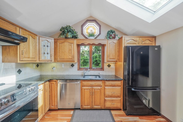 6 Sunrise Pl, Farmingville, NY 11738 - kitchen featuring appliances with stainless steel finishes, light wood-style flooring, lofted ceiling, a skylight, and dark stone countertops