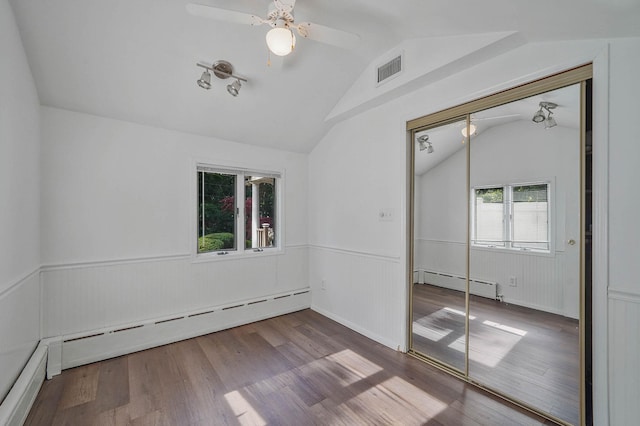 6 Sunrise Pl, Farmingville, NY 11738 - unfurnished room with a baseboard radiator, lofted ceiling, a wainscoted wall, wood finished floors, and a ceiling fan