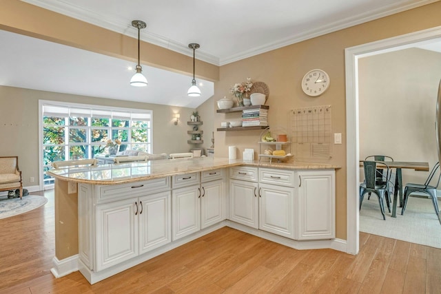 92 Wiltshire Rd, Scarsdale, NY 10583 - kitchen with light wood-style floors, a peninsula, white cabinets, decorative light fixtures, and crown molding