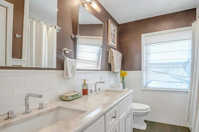 92 Wiltshire Rd, Scarsdale, NY 10583 - bathroom with tile walls, double vanity, and wainscoting