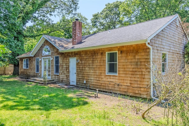 82A Union Ave, Center Moriches, NY 11934 - rear view of house featuring french doors, a chimney, roof with shingles, and a lawn
