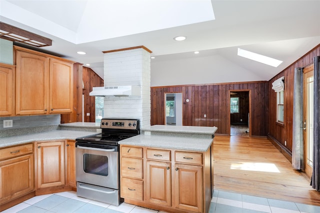 82A Union Ave, Center Moriches, NY 11934 - kitchen with stainless steel range with electric cooktop, ventilation hood, vaulted ceiling, wooden walls, and a peninsula