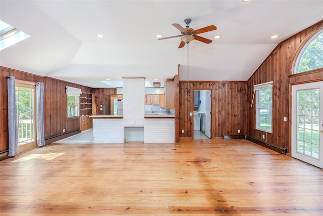 82A Union Ave, Center Moriches, NY 11934 - unfurnished living room featuring lofted ceiling, wooden walls, healthy amount of natural light, ceiling fan, and baseboard heating