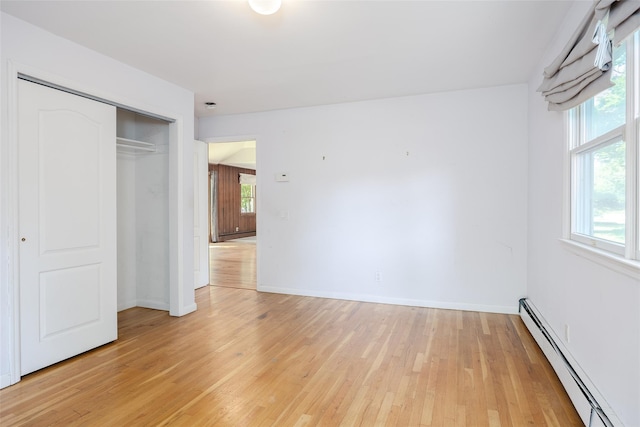 82A Union Ave, Center Moriches, NY 11934 - unfurnished bedroom featuring a baseboard heating unit, light wood finished floors, and a closet
