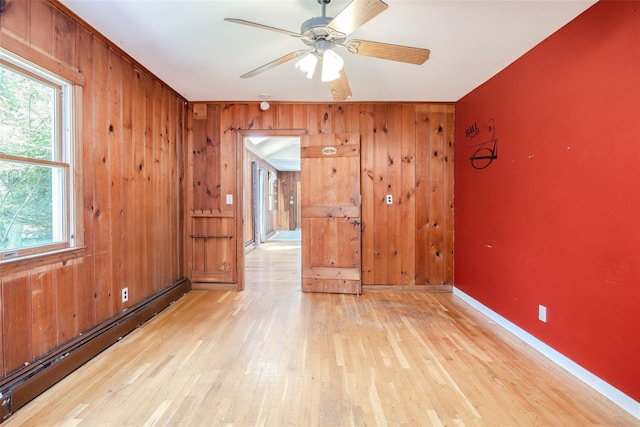 82A Union Ave, Center Moriches, NY 11934 - unfurnished room featuring a baseboard heating unit, light wood-type flooring, wood walls, and ceiling fan