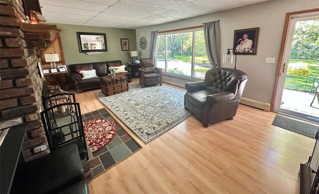 282 Petticoat Ln, Bloomingburg, NY 12721 - living area featuring baseboard heating, a drop ceiling, and wood finished floors
