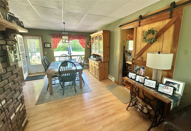 282 Petticoat Ln, Bloomingburg, NY 12721 - dining room with a drop ceiling, a baseboard radiator, light wood-style flooring, and a barn door