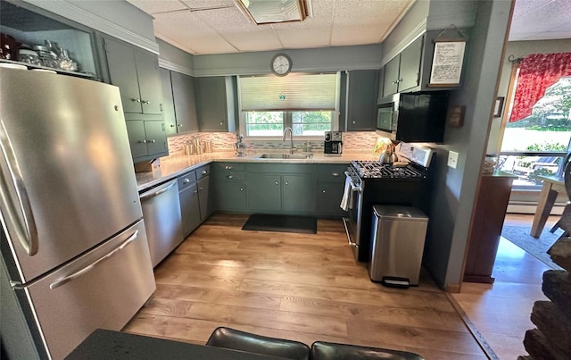 282 Petticoat Ln, Bloomingburg, NY 12721 - kitchen featuring appliances with stainless steel finishes, light wood-style floors, green cabinets, tasteful backsplash, and a paneled ceiling