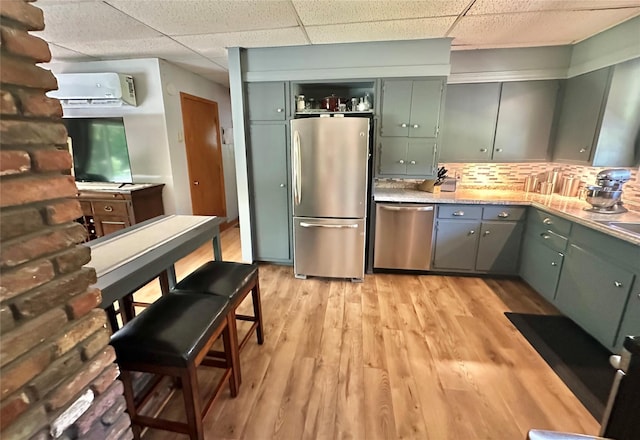 282 Petticoat Ln, Bloomingburg, NY 12721 - kitchen with stainless steel appliances, a wall mounted AC, a paneled ceiling, light wood finished floors, and light countertops