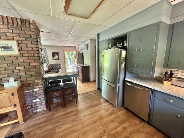 282 Petticoat Ln, Bloomingburg, NY 12721 - kitchen with appliances with stainless steel finishes, a drop ceiling, light wood finished floors, open shelves, and a wall mounted air conditioner