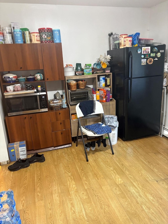 40 Samuel St, Ronkonkoma, NY 11779 - kitchen featuring freestanding refrigerator, stainless steel microwave, light wood-style flooring, brown cabinets, and dark countertops