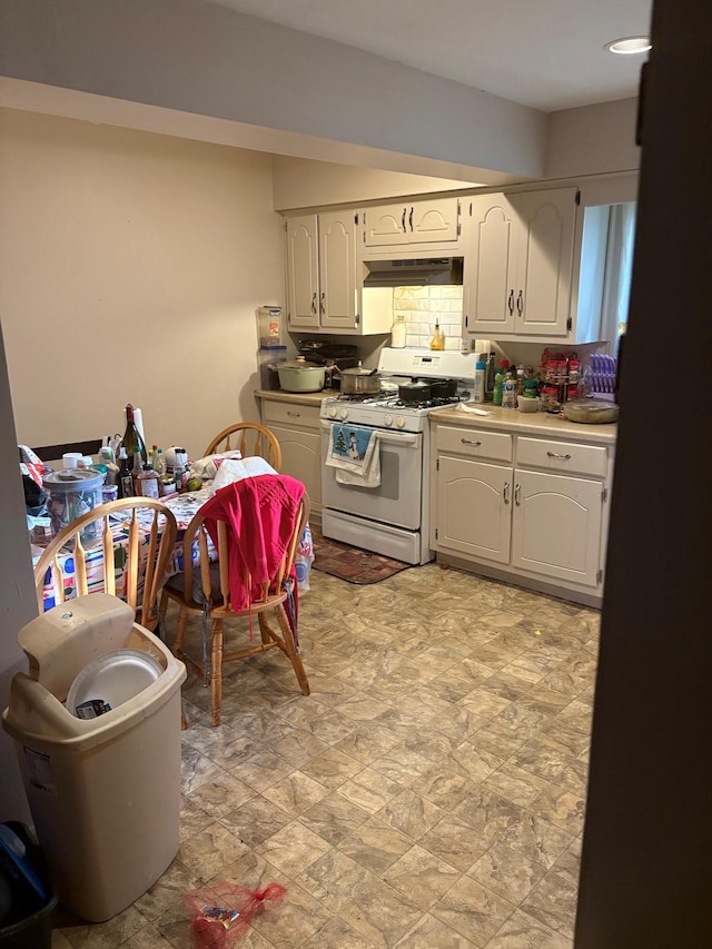 40 Samuel St, Ronkonkoma, NY 11779 - kitchen with white gas stove, under cabinet range hood, white cabinetry, and light countertops