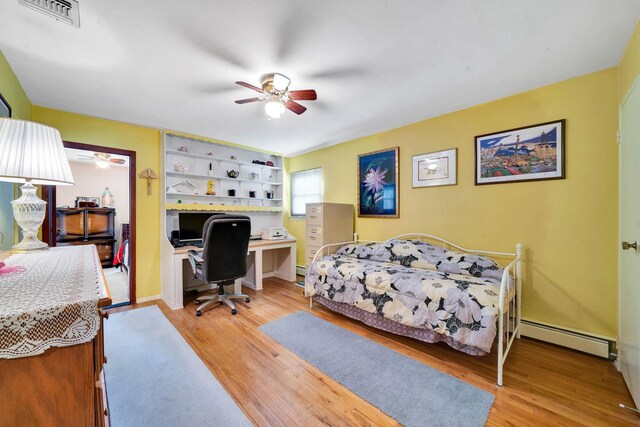47 Tucker Dr, Bayport, NY 11705 - bedroom with baseboard heating, an office area, light wood finished floors, and ceiling fan