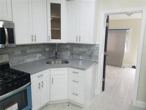 2718 Holland Ave, Bronx, NY 10467 - kitchen featuring appliances with stainless steel finishes, decorative backsplash, and white cabinets
