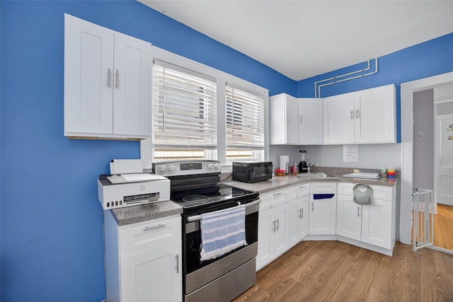 439 S 7th Ave, Mount Vernon, NY 10550 - kitchen featuring stainless steel electric stove, black microwave, light wood-style floors, white cabinetry, and light countertops