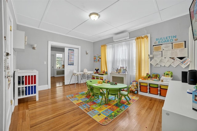 439 S 7th Ave, Mount Vernon, NY 10550 - playroom with a wall mounted air conditioner, wood finished floors, and radiator
