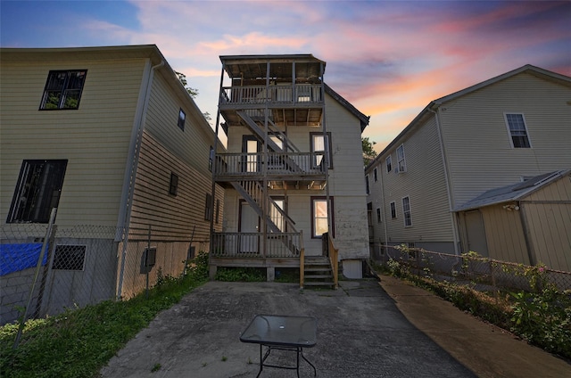 439 S 7th Ave, Mount Vernon, NY 10550 - back of house at dusk with a patio, a balcony, and stairway